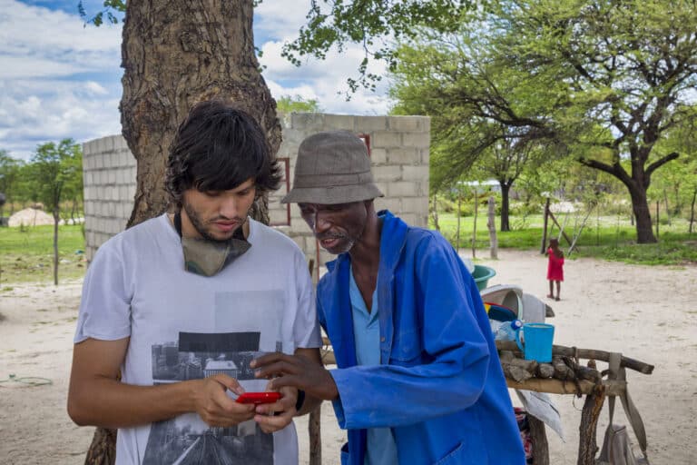 2 friends using the phone in the township in Africa