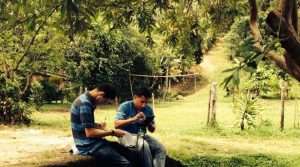 two individuals sitting beside the road