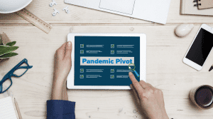 Hand holding tablet with Pandemic pivot on the screen