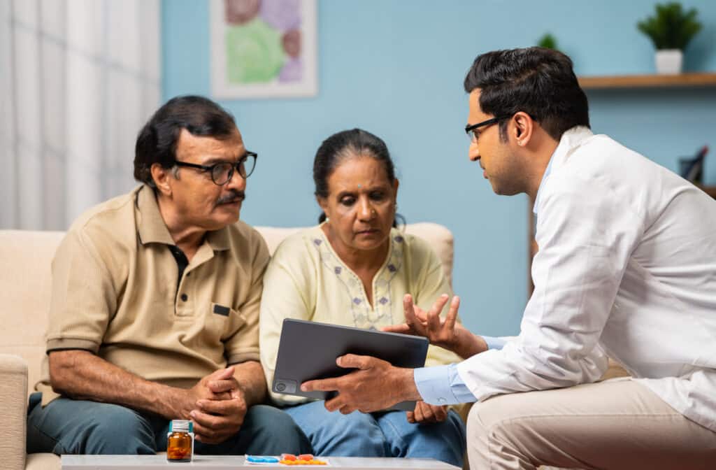 A doctor in India meets with an older couple for a community health consultation.