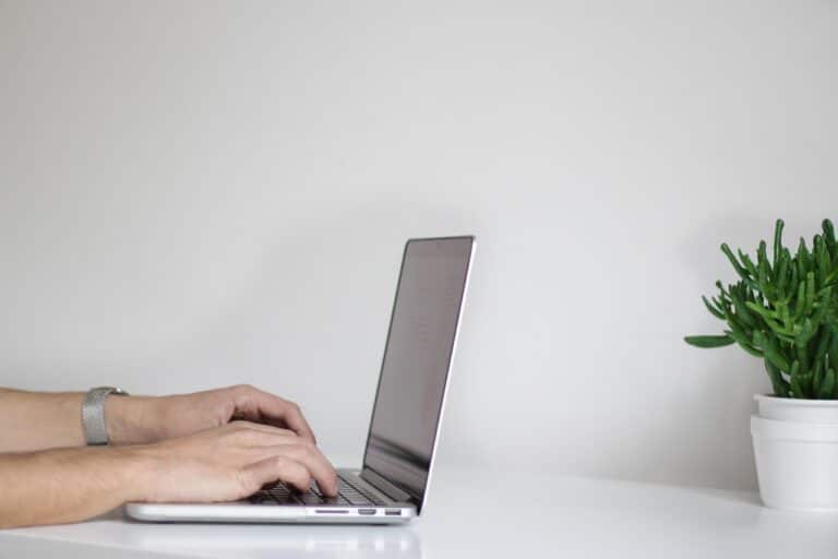 Hands typing on a laptop.